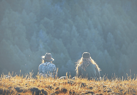 Idaho contact 2 two women sitting in a field overlooking Idaho mountains