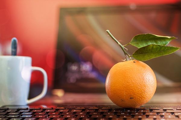 office desk with an orange on it