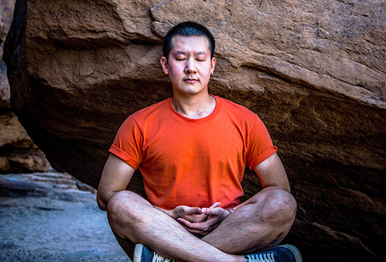 mind body soul man meditating outdoor near rock