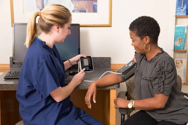 nurse taking woman's blood pressure