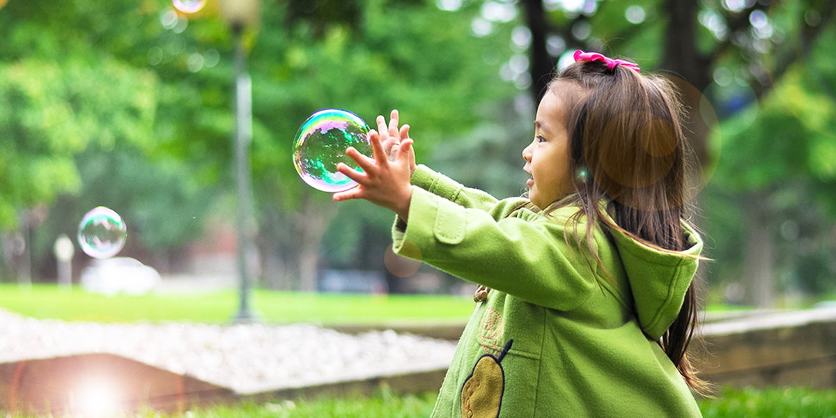 young girl playing with bubbles