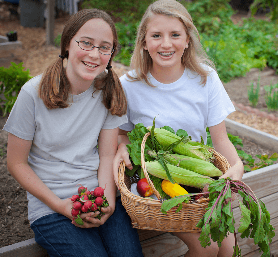 Girls with corn basket in garden