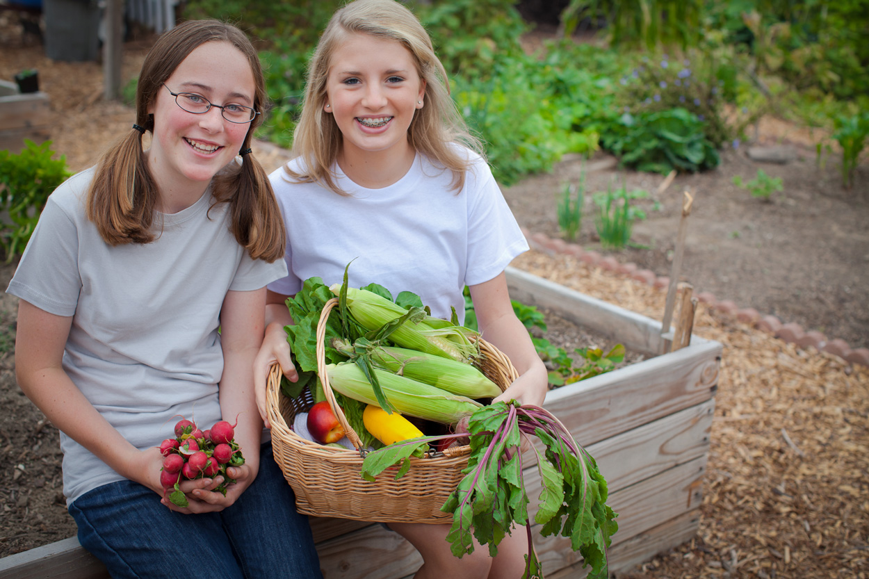 Girls with corn basket in garden