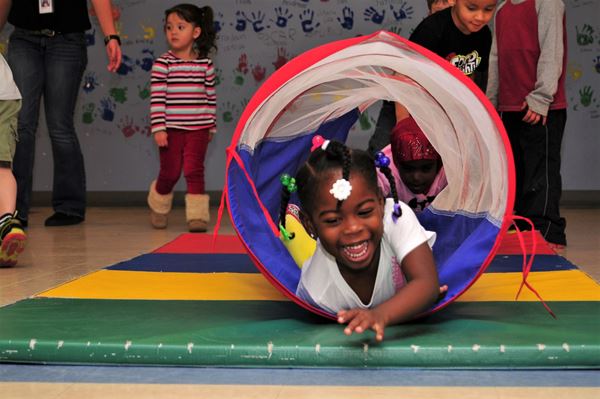 young girl crawling through tunnel