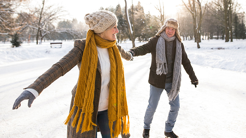 middle aged man and woman couple ice skating outside