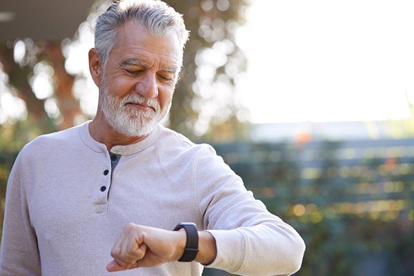 Senior man looking at Apple Watch