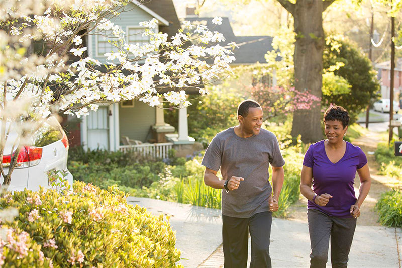 Older couple jogging through the neighborhood Older couple jogging through the neighborhood