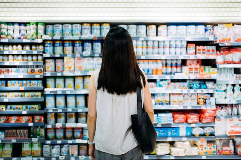 Woman looking at yogurt on grocery shelves