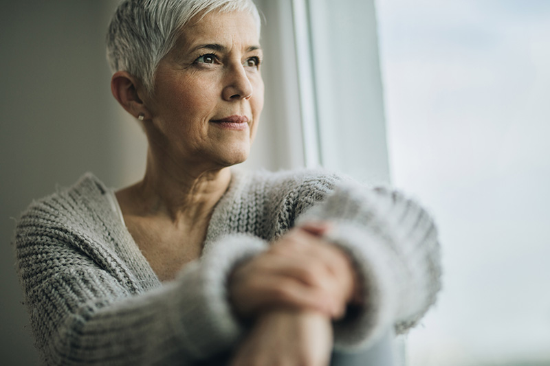 mature woman looking out window