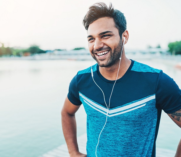 man exercising outdoors while listening to music and smiling man exercising outdoors while listening to music and smiling