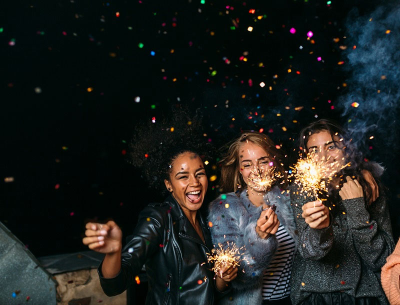group of girls laughing while holding sparkler fireworks group of girls laughing while holding sparkler fireworks