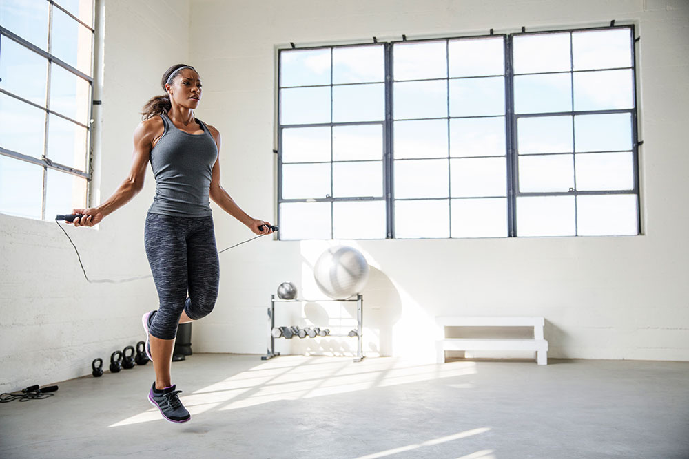 Athletic woman jumping rope at gym