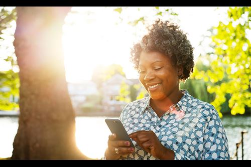 happy woman texting outdoors in sunlight happy woman texting outdoors in sunlight