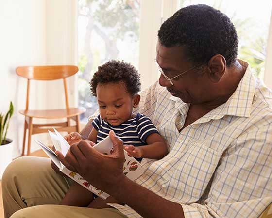 grandpa reading book to baby grandson