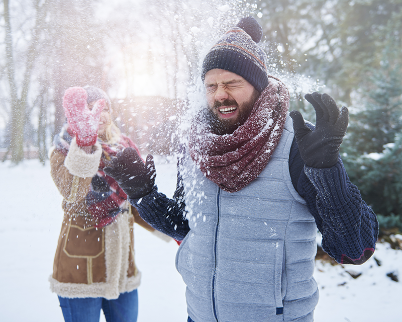 woman hitting man in face with a snowball