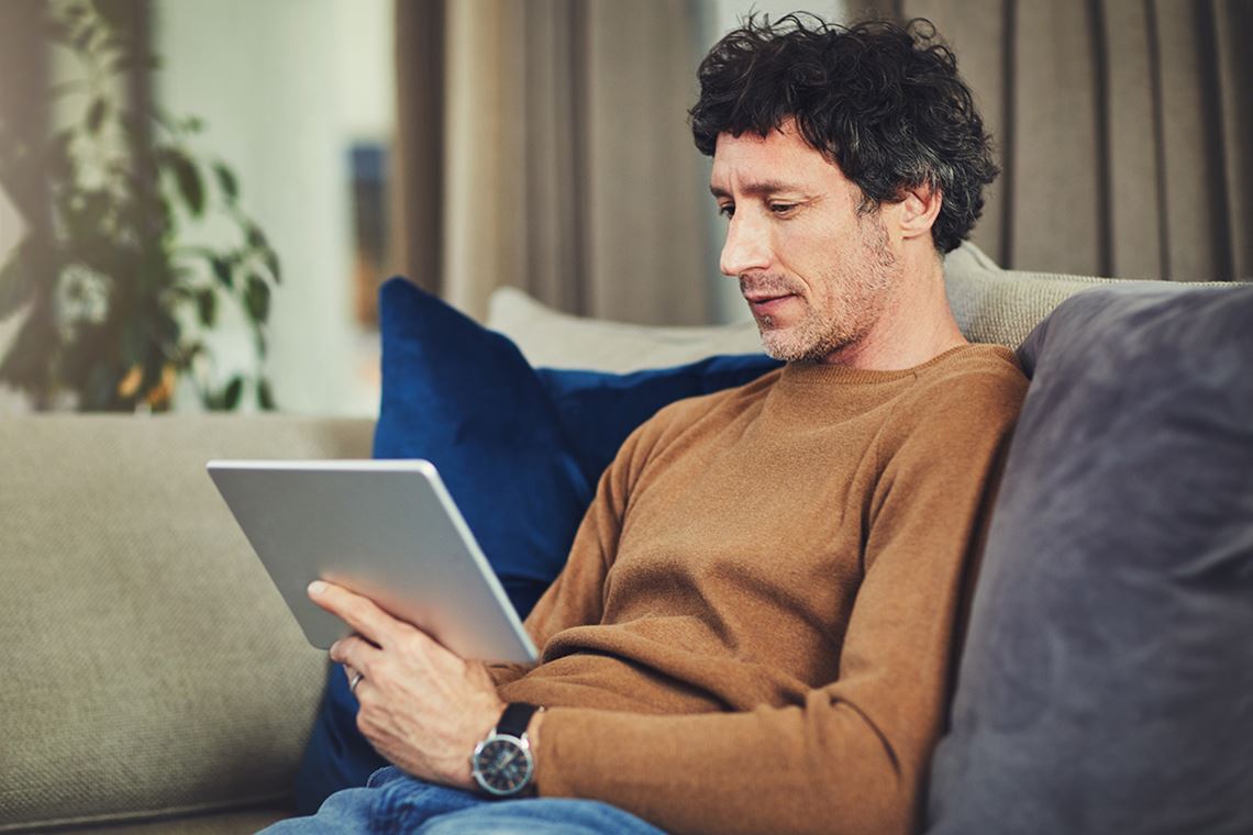 Middle age man on tablet at home