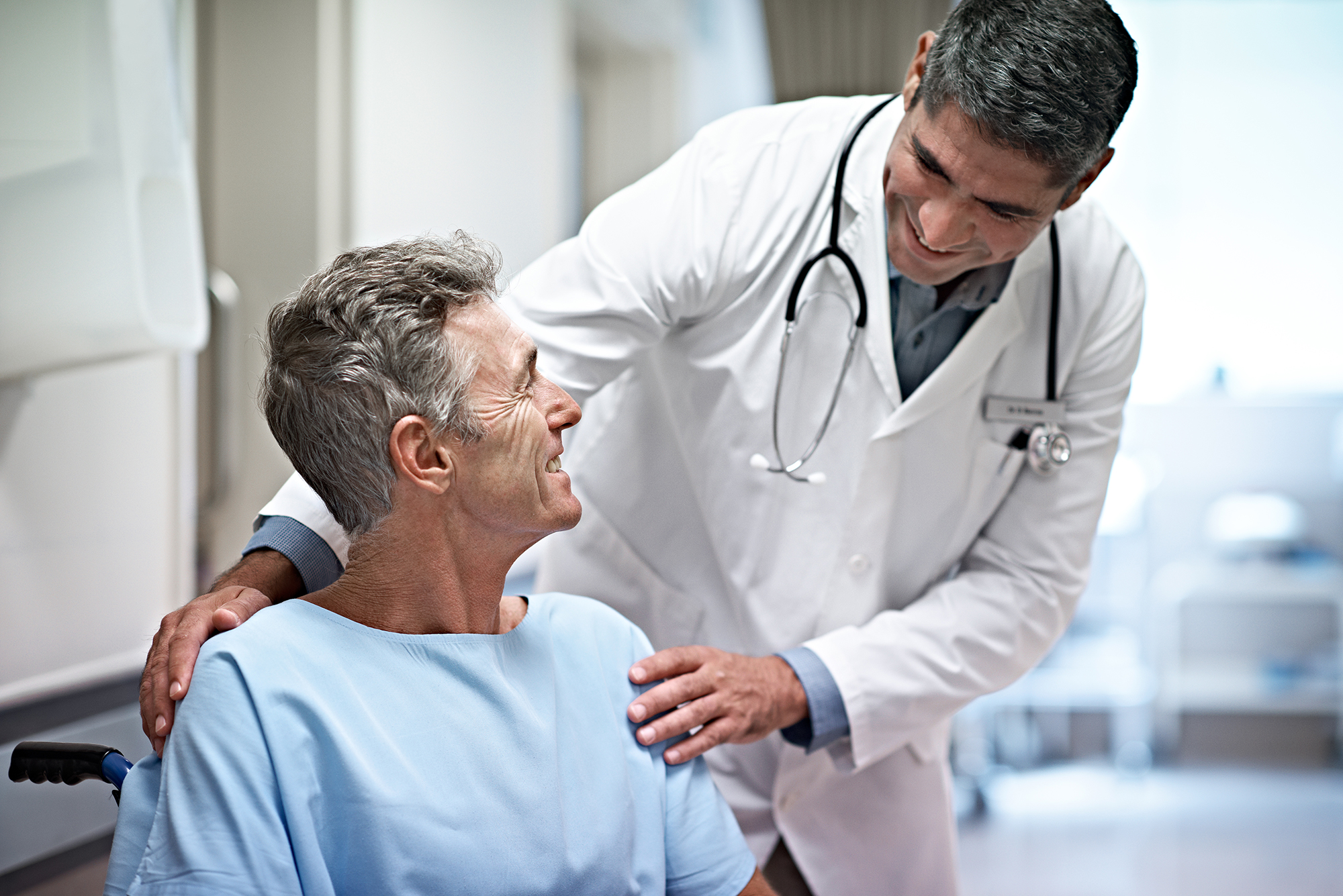 doctor speaking with patient in wheelchair