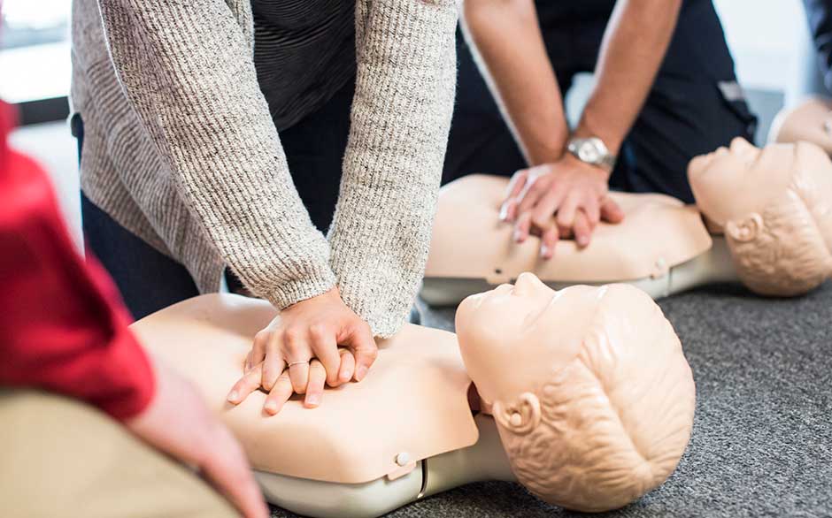 students practicing CPR on manikin