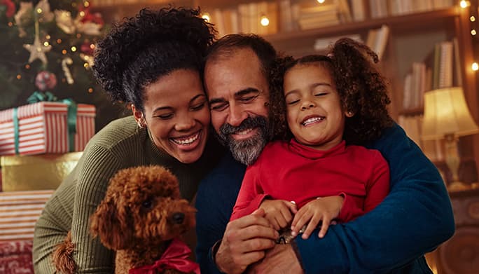 Family of 3 smiling during the holidays