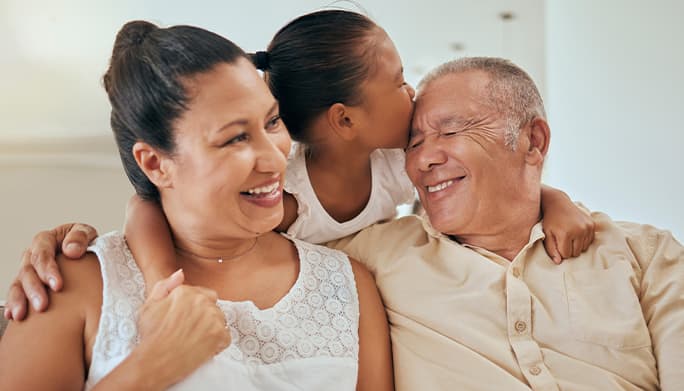 Family of three smiling on couch