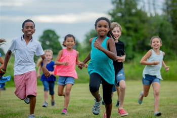 A group of young school children running outside