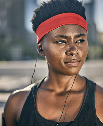 woman runner wearing headband listens to music