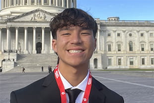 Magnus Miller posing for photo in front of United States capitol building with a big smile