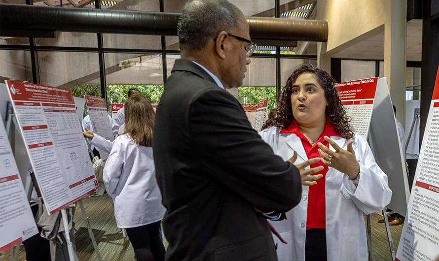 An American Heart Association Scholar is presenting her scientific poster to a program mentor. An American Heart Association Scholar is presenting her scientific poster to a program mentor.