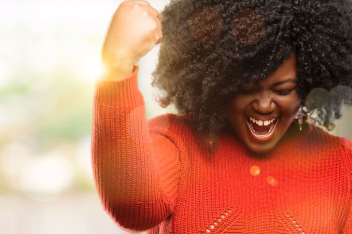 woman in red holding her fist up in celebration