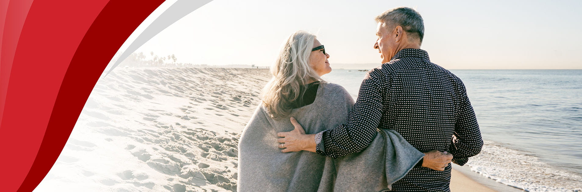 an older couple walking together on the beach