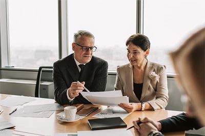 An advisor talking through some documents with a client at a conference table