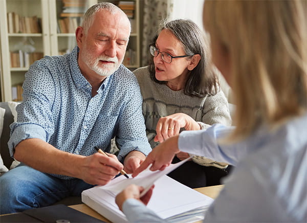 An older couple reviews documents with an advisor