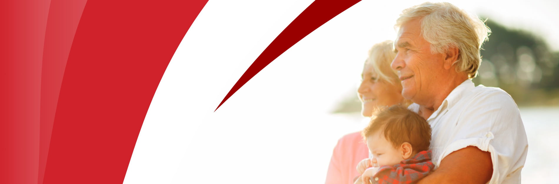 Grandparents holding toddler, staring into the distance in the sunlight
