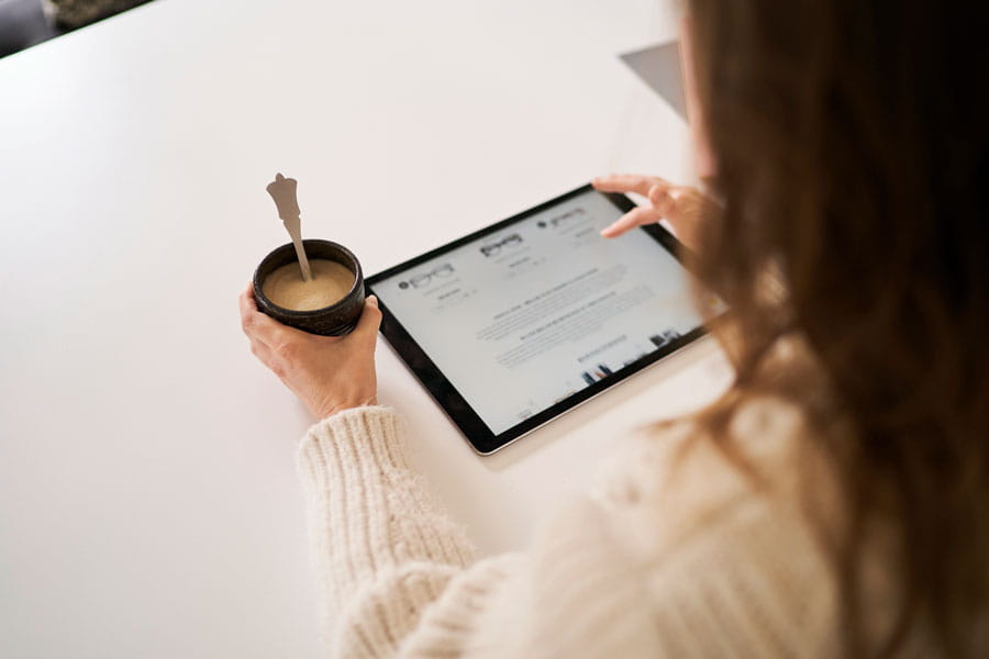 Woman looking at her table and holding coffee mug