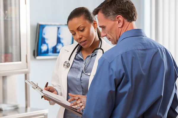 man talking to woman doctor man talking to woman doctor