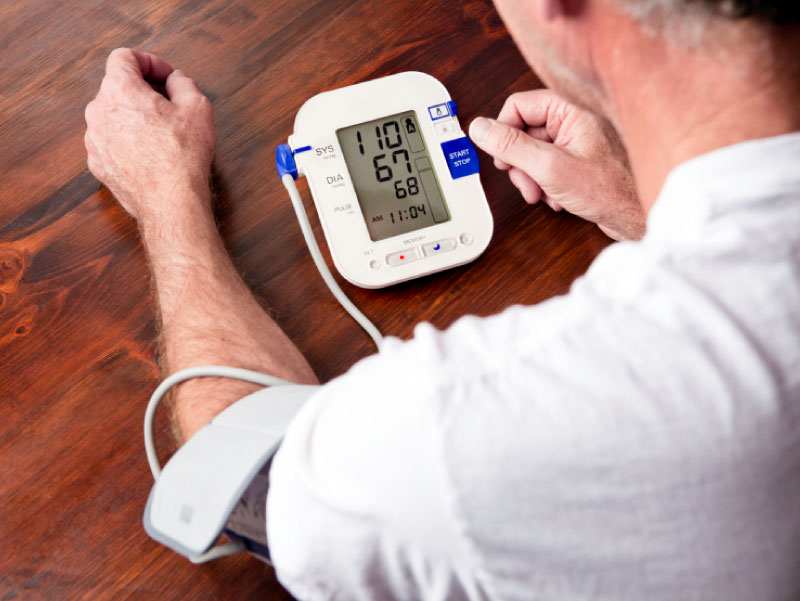 Man taking blood pressure at home.