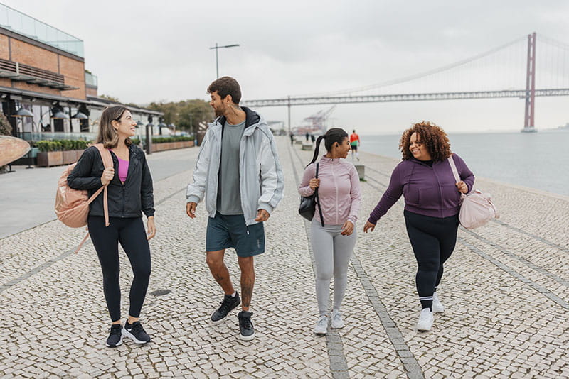 four people walking together outdoors and chatting