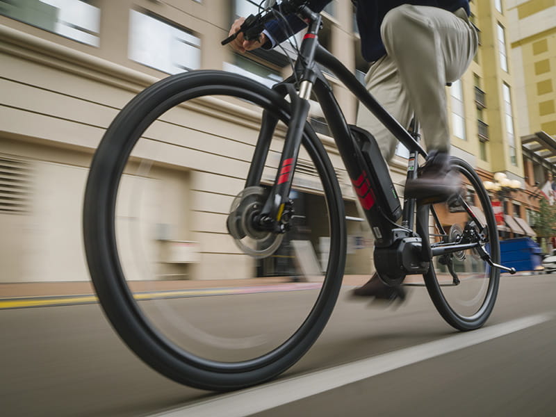 Man riding an e-0bike on the street.
