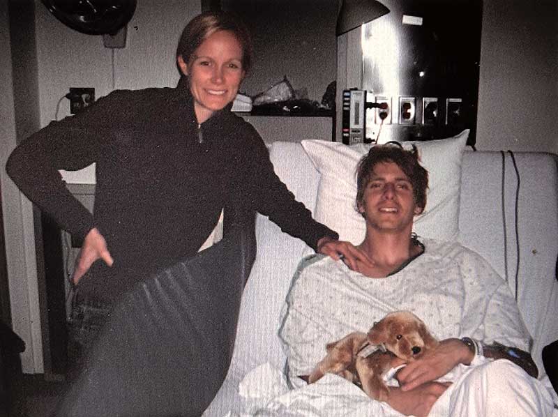 Jared and Alison Hankins. Jared is in a hospital bed holding a stuffed animal while Allison is standing next to him. Both are smiling.