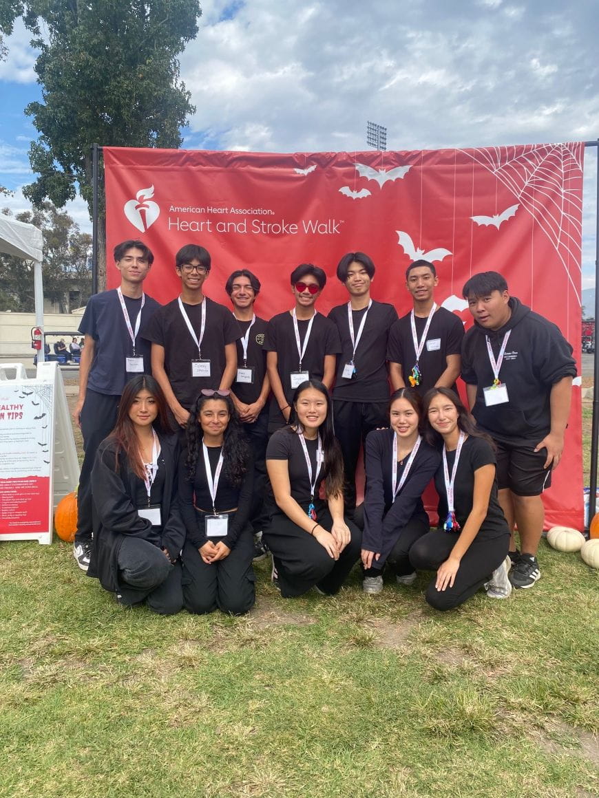 Students standing in front of a red Heart Walk sign