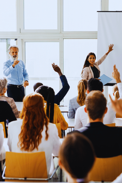 Students in a classroom raising their hands