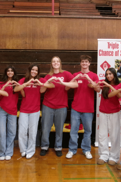 Students wearing red holding their hands in hearts