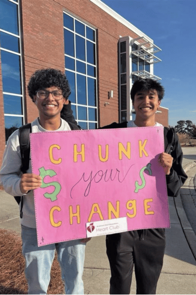 Two Students holding "Chunk your Change" fundraising sign
