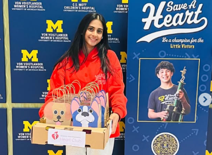 Student holding care packages in front of signs
