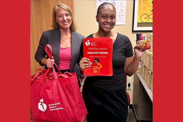 two Rural at Heart volunteers displaying maternal health materials