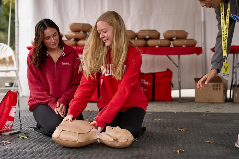Two people practicing Hands-Only CPR