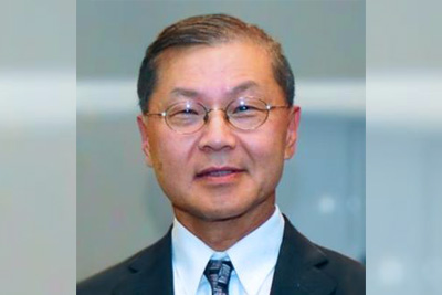 A professional portrait of David Ho, MD, on a neutral abstract background