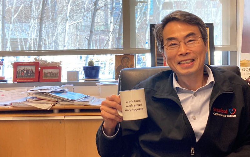 In his office, Dr. Joseph Wu’s coffee mug displays the mantra he teaches his mentees: “Work hard / Work smart / Work together.” The mug was a gift from one of those mentees. (American Heart Association)